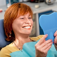 Senior woman looking at smile in mirror